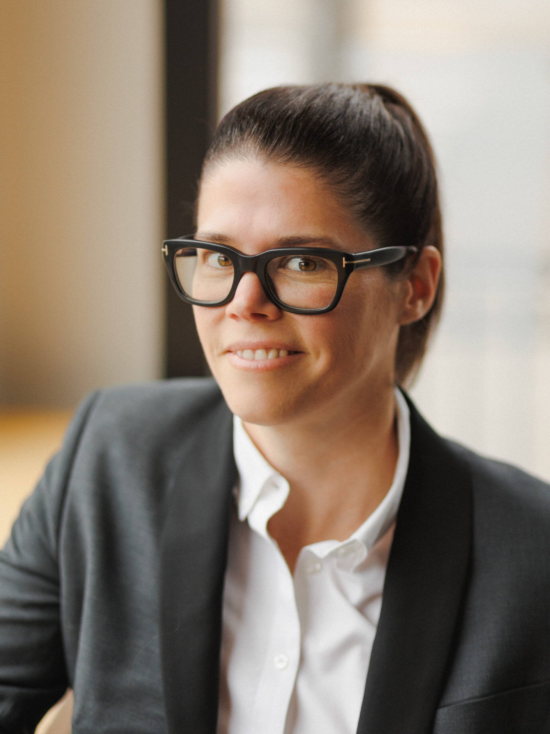 woman with glasses and suit jacket